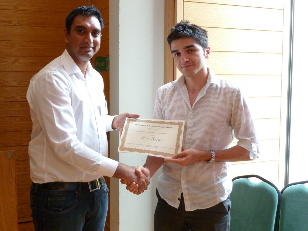 Nima Keivan receiving the Springer Best Paper Award from Ashutosh Natraj